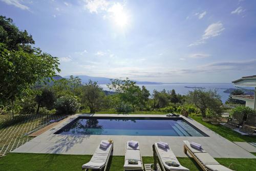 a swimming pool with lounge chairs and the ocean at Villa Dolce Bellezza in Salò