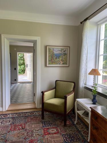 a living room with a chair and a door at Bed & Breakfast Vragerups Gård in Lomma