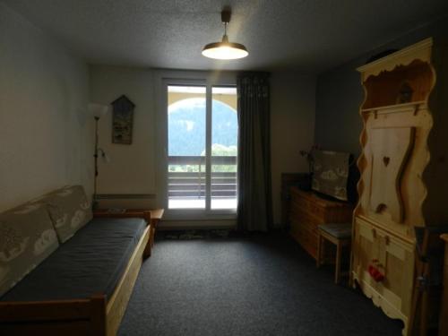 une chambre avec un lit et une grande fenêtre dans l'établissement Studio cabine au pied des pistes - FR-1-557A-7, à La Ferrière