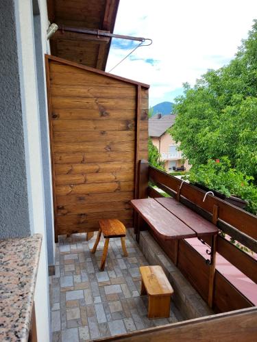 a wooden bench and stool on a balcony at House Sara in Korenica