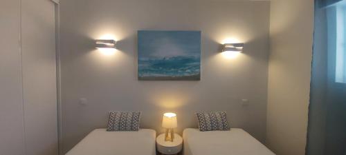 a room with two beds and two lights on the wall at Apartamento S. João in Alvor