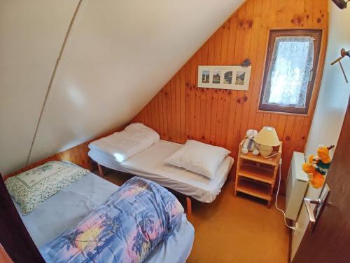 a attic room with two beds and a window at Chalet Barcelonnette, 4 pièces, 8 personnes - FR-1-165A-69 in Barcelonnette