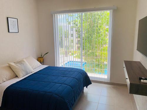 1 dormitorio con cama azul y ventana grande en Franks House Apartment "Shared House" en Cancún
