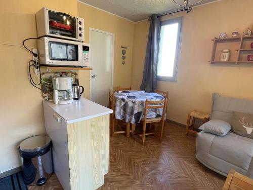 Il comprend une petite cuisine et un salon avec une table. dans l'établissement Studio au Sauze avec balcon, 4 pers, parking - FR-1-165A-88, à Enchastrayes