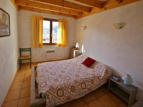 - une chambre avec un lit doté d'un couvre-lit rouge et d'une fenêtre dans l'établissement Maison calme avec terrasse, garage et barbecue - FR-1-165A-91, à Saint-Pons