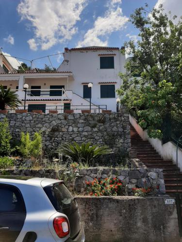 a white car parked in front of a house at Arcomagno Guest House in San Nicola Arcella