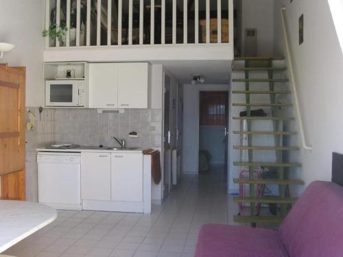 une cuisine avec des placards blancs et un escalier en colimaçon dans l'établissement T2 mezzanine 35m² avec terrasse, parking, 6 pers - Sète - FR-1-472-108, à Sète