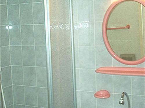 La salle de bains est pourvue d'une douche et d'un miroir rond. dans l'établissement T2 mezzanine 35m² avec terrasse, parking, 6 pers - Sète - FR-1-472-108, à Sète