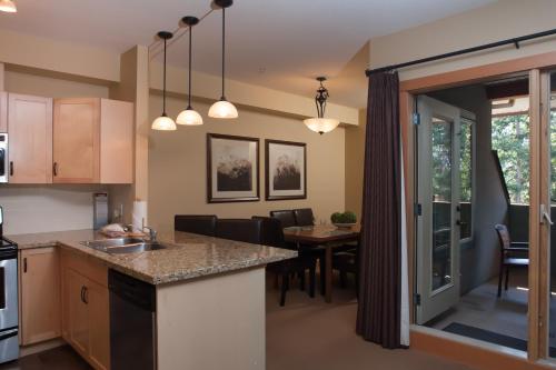 an open kitchen and dining room with a dining table at Lodges at Canmore in Canmore