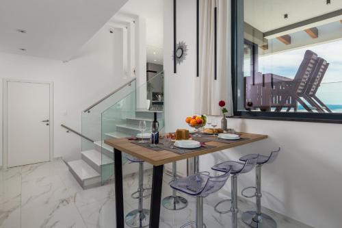 a dining room with a table and two stools at House7E in Šmrika