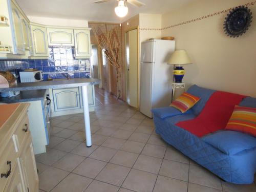 un salon avec un canapé bleu dans une cuisine dans l'établissement T2 bien entretenu avec loggia et parking à Sète - FR-1-472-119, à Sète