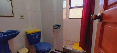 a bathroom with a blue toilet and a sink at Suma Uta in Copacabana