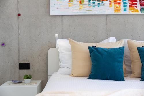 a bedroom with a bed with blue and white pillows at House7E in Šmrika