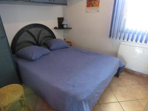 une chambre avec un lit avec des draps bleus et une fenêtre dans l'établissement T2 bien entretenu avec loggia et parking à Sète - FR-1-472-119, à Sète