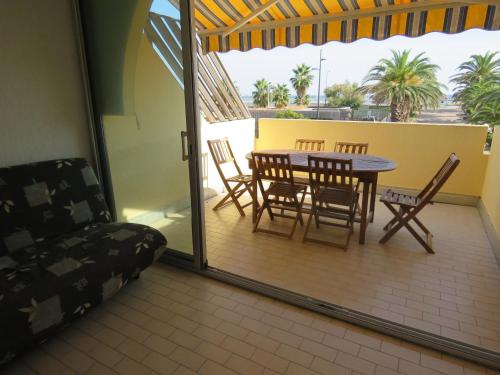 un patio avec une table et des chaises sur un balcon dans l'établissement Appartement T2 à Sète - Terrasse, Loggia, Front de Mer, Parking Privé - FR-1-472-121, à Sète