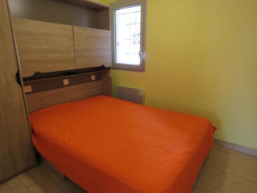 - un lit orange dans une chambre avec fenêtre dans l'établissement Appartement T2 à Sète - Terrasse, Loggia, Front de Mer, Parking Privé - FR-1-472-121, à Sète