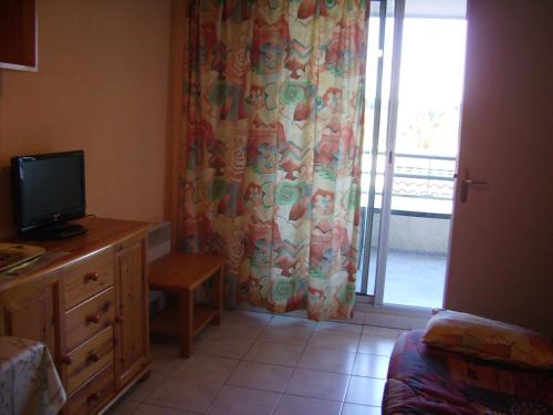 d'un salon avec une télévision et une porte coulissante en verre. dans l'établissement Charmant T2 Cabine Climatisé avec Terrasse et Parking à Sète, Proche Plage et Commerces - FR-1-472-128, à Sète