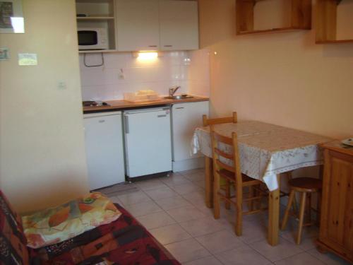 - une petite cuisine avec une table et un comptoir dans l'établissement Charmant T2 Cabine Climatisé avec Terrasse et Parking à Sète, Proche Plage et Commerces - FR-1-472-128, à Sète