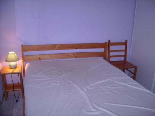 une chambre avec un lit avec des draps blancs et une lampe dans l'établissement Charmant T2 Cabine Climatisé avec Terrasse et Parking à Sète, Proche Plage et Commerces - FR-1-472-128, à Sète