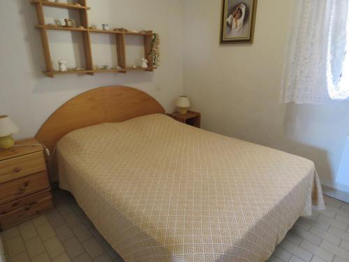 une chambre avec un lit et une tête de lit en bois dans l'établissement Charmant T2 à Sète avec Loggia et Parking - FR-1-472-123, à Sète