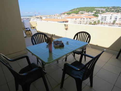une table et des chaises sur un balcon avec vue dans l'établissement T2 cabine 35m² dernier étage, terrasse, parking - FR-1-472-136, à Sète