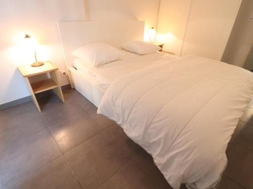 une chambre avec un lit blanc et une table de chevet dans l'établissement T3 75m² avec Terrasse et Double Parking à Sète - FR-1-472-141, à Sète