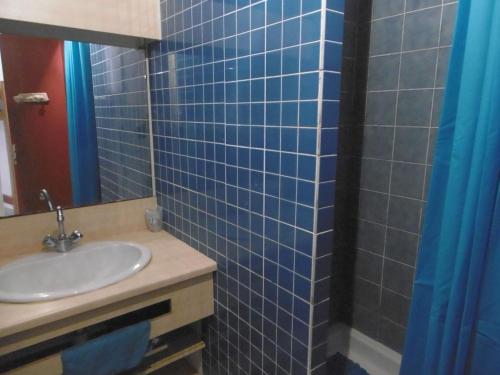 bagno piastrellato blu con lavandino e specchio di Appartement Sète, 2 pièces, 5 personnes - FR-1-472-143 a Sète