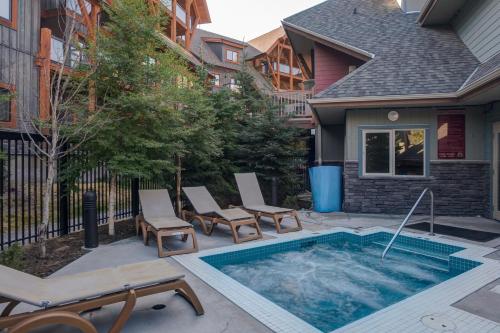 a swimming pool with chairs next to a house at Lodges at Canmore in Canmore