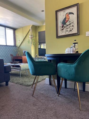 a waiting room with two green chairs and a table at The Clontarf in Llandudno