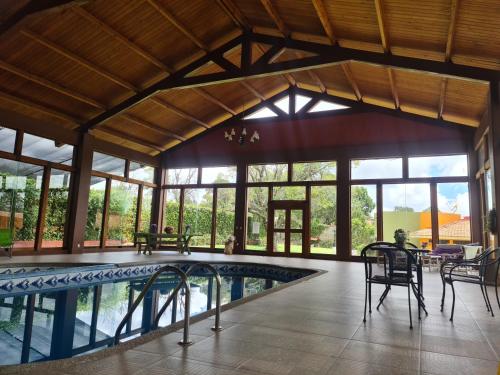 a large room with a pool and tables and chairs at Finca Los Angeles Hospederia & Sociales in Huasca de Ocampo
