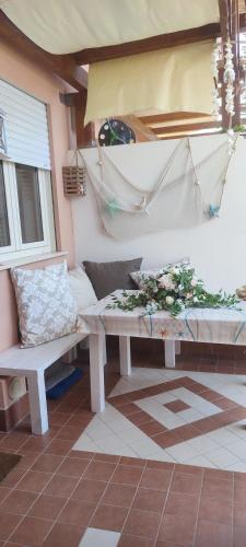 a bench sitting on a porch with flowers on it at Le Torrette di Anna - Tropea in Briatico