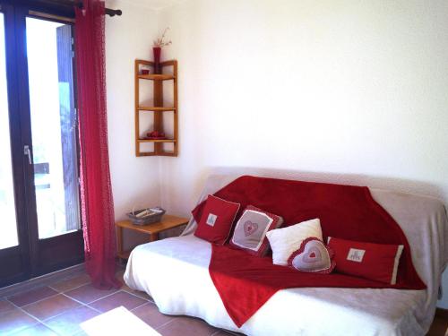 une chambre avec un lit avec des oreillers rouges et blancs dans l'établissement Charmant appartement T2 à Barcelonnette, 4 pers, balcon avec vue, parking - FR-1-165A-104, à Barcelonnette