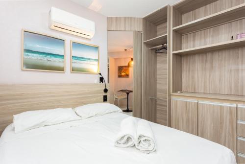 Un dormitorio con una cama blanca con toallas. en Beach Class Santa Maria by Easy Home en Recife