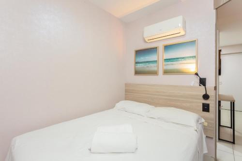 a white bedroom with a white bed and two windows at Beach Class Santa Maria by Easy Home in Recife