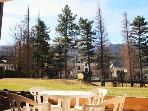 d'une table et de chaises avec vue sur un champ dans l'établissement T2 Centre Barcelonnette avec Garage, Terrasse et Parc Privé - FR-1-165A-101, à Barcelonnette