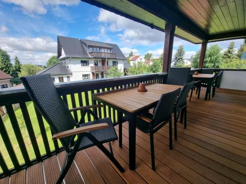 a wooden table and chairs on a balcony at Ferienhaus Kaiserhof in Markkleeberg
