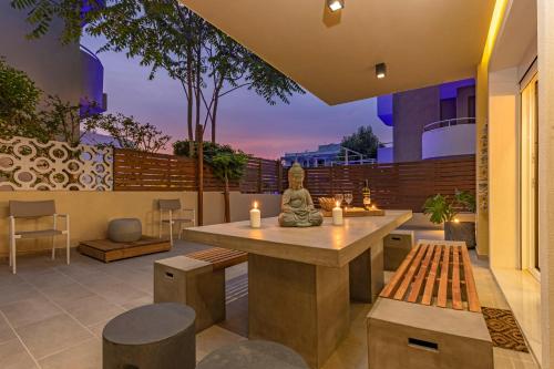 a patio with a statue on a table with candles at Elia & Anthos Deluxe Suites in Ixia