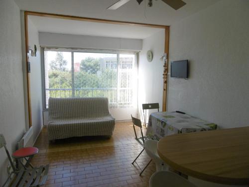 - un salon avec une table, un canapé et une fenêtre dans l'établissement Sète: Studio cabine 4 pers avec accès direct plage, parking privatif - FR-1-472-152, à Sète