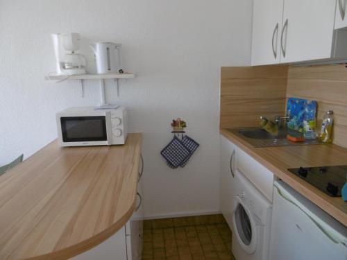 - une cuisine avec un comptoir, un four micro-ondes et un évier dans l'établissement Sète: Studio cabine 4 pers avec accès direct plage, parking privatif - FR-1-472-152, à Sète