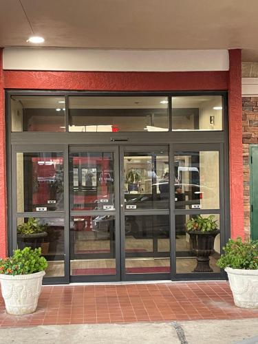 a store front with glass doors and two plants at Ramada by Wyndham Oklahoma City Airport North in Oklahoma City