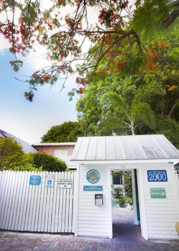 a white building with a sign on it at Courtney's Place Historic Cottages & Inns in Key West
