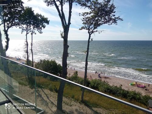 uma vista para a praia a partir da varanda de um edifício em Apartament z widokiem na morze w kompleksie Hevenia em Rewal