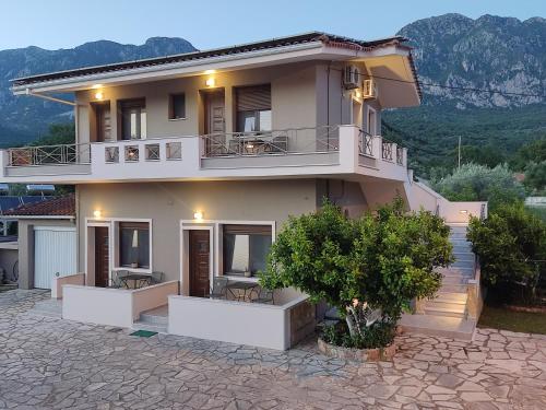 a large house with balconies on a stone patio at Erietta Rooms in Paramythia