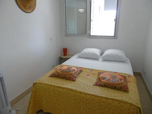 une chambre avec un lit avec deux oreillers dessus dans l'établissement Appartement 35m² avec loggia, parking privé à Sète - FR-1-472-159, à Sète