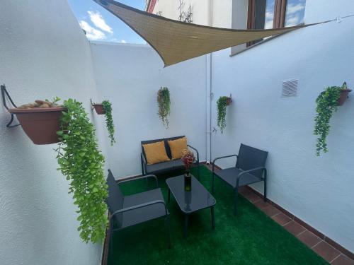 a patio with two chairs and a table with plants at Carmen Aljibe de la Miel in Granada