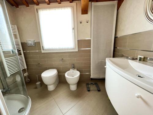 a bathroom with a toilet and a sink and a tub at ERMAN HOUSE Mansarda sulla Riviera del Brenta Venezia in Dolo