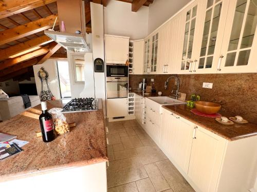 a kitchen with white cabinets and a counter with a sink at ERMAN HOUSE Mansarda sulla Riviera del Brenta Venezia in Dolo
