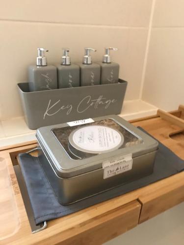 a cake with six clocks in a box on a table at Key Cottage, sleeps 8 in Brimscombe