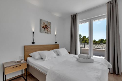 een slaapkamer met een bed en een groot raam bij Apartment Villa Barisimo in Makarska