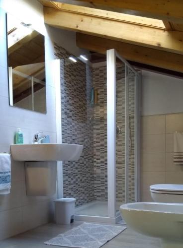 a bathroom with a sink and a toilet and a mirror at Dreaming Feriolo - mansarded apartment by Danilo Apartments in Baveno